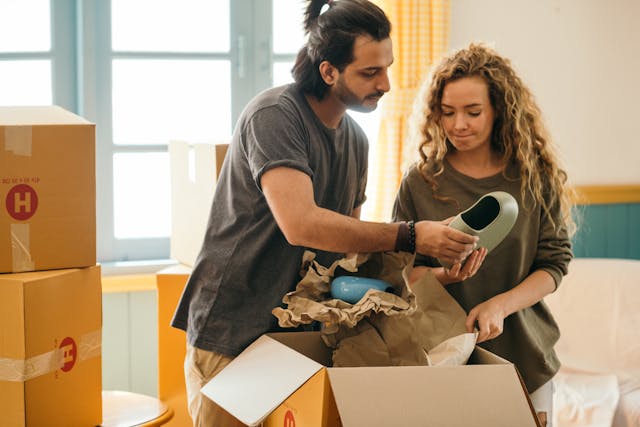 A couple sorting through items and packing for their move, focusing on downsizing before a move with carefully packed boxes and belongings.